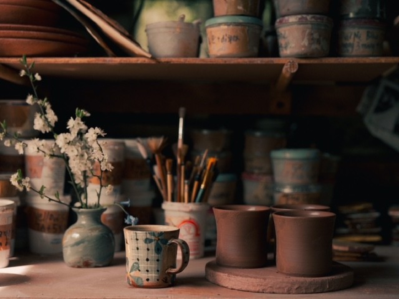 pottery workshop with some finished and work-in-progress mugs