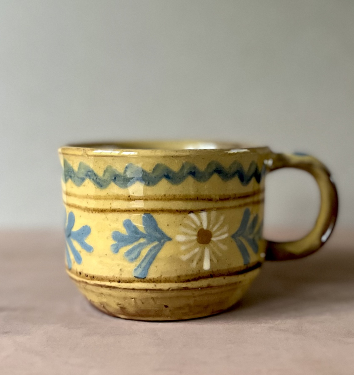 Straight sided yellow cup with white daisy